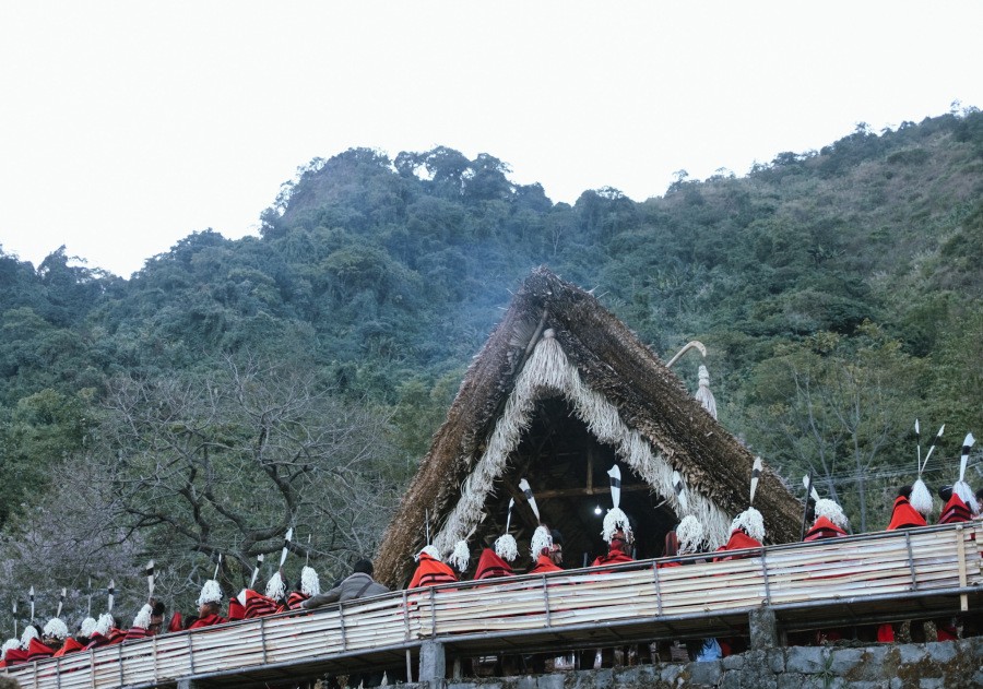 A group of Naga men sit outside a tribal morung at the Naga Heritage Village, Kisama, during the Hornbill Festival. (Photo Courtesy: Twitter@nagalandtourism | Representational Image)